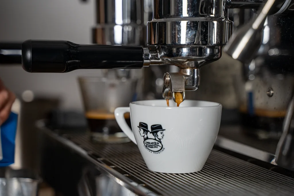 Espresso die uit een espressomachine in een kopje van Lorando & Morini loopt.