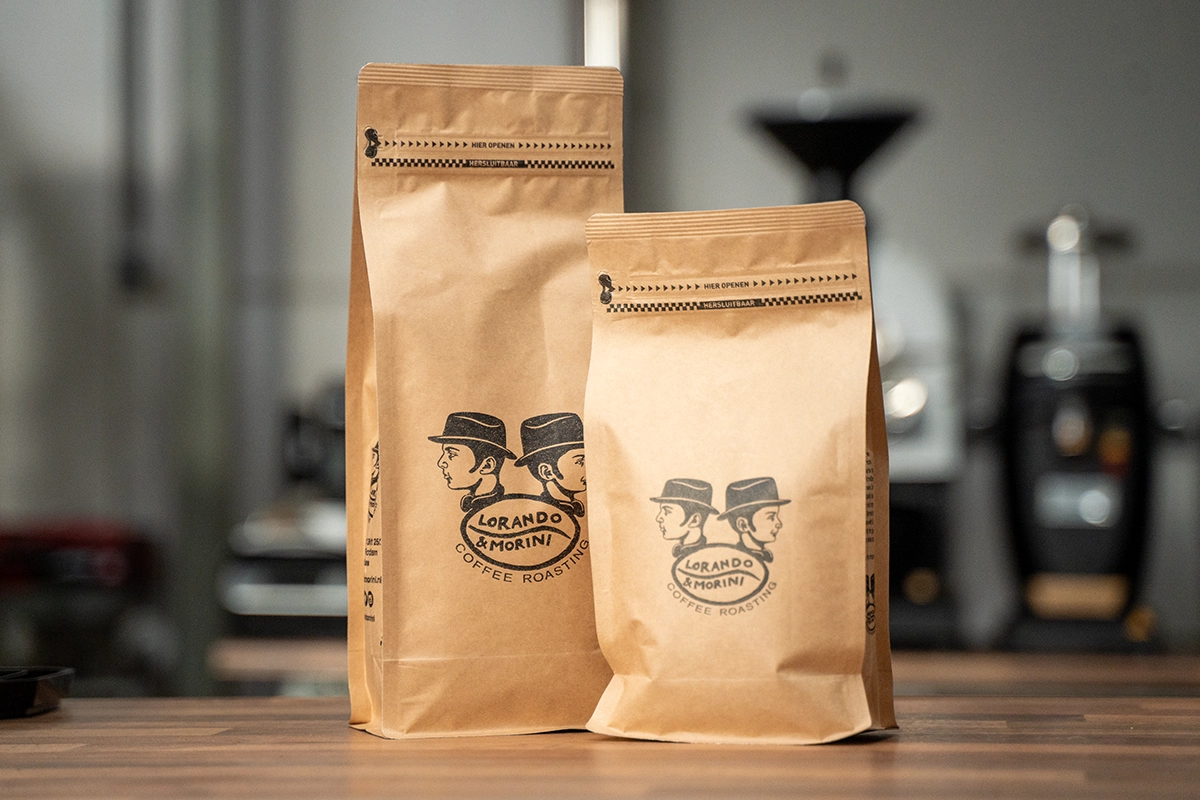 Koffieverpakkingen van Lorando & Morini met vers gebrande specialty koffiebonen op een houten tafel.