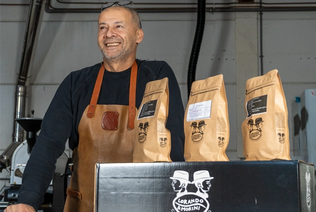 Koffiebrander staat naast verpakkingen met vers gebrande koffiebonen van Lorando & Morini.